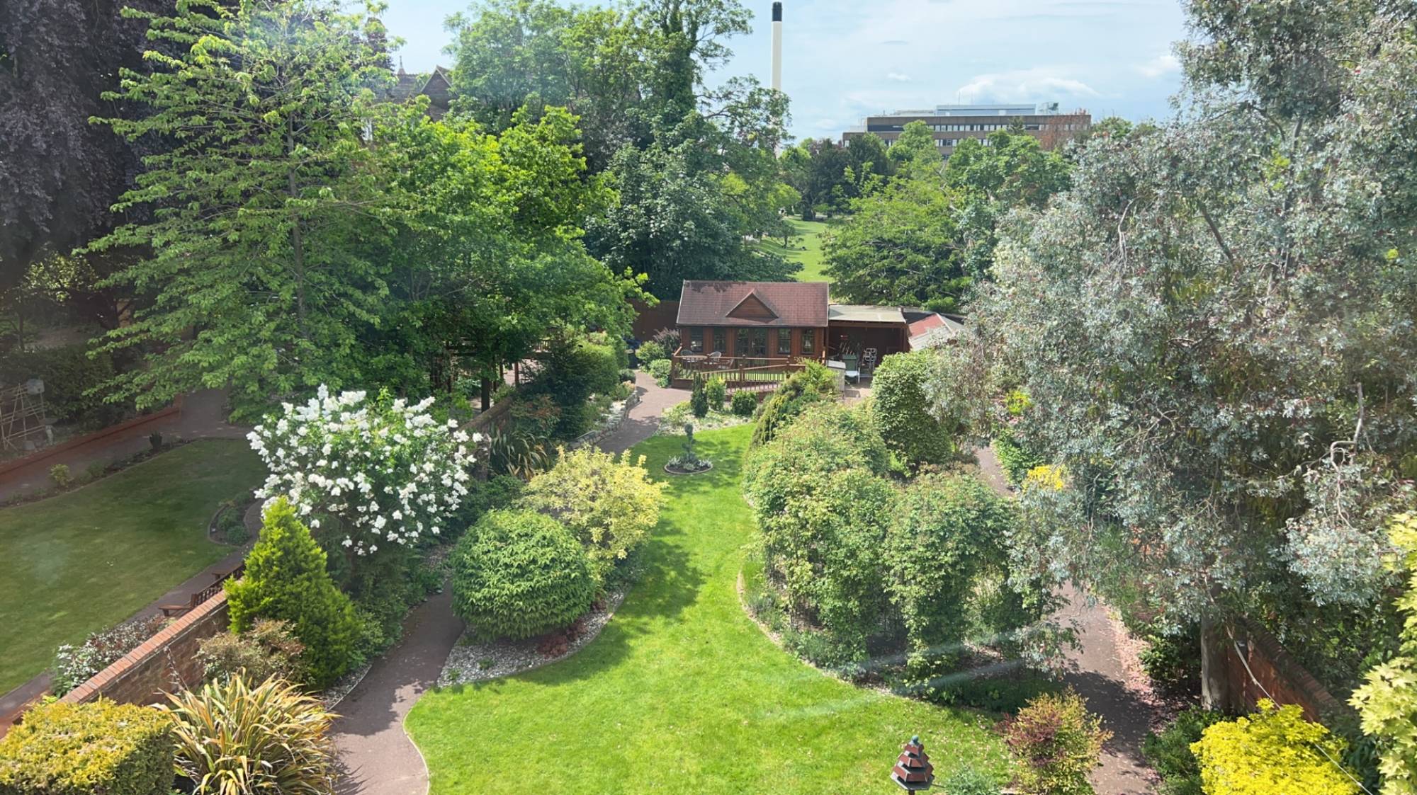 The landscaped gardens at Pembroke from above, with winding paths leading to the garden summerhouse